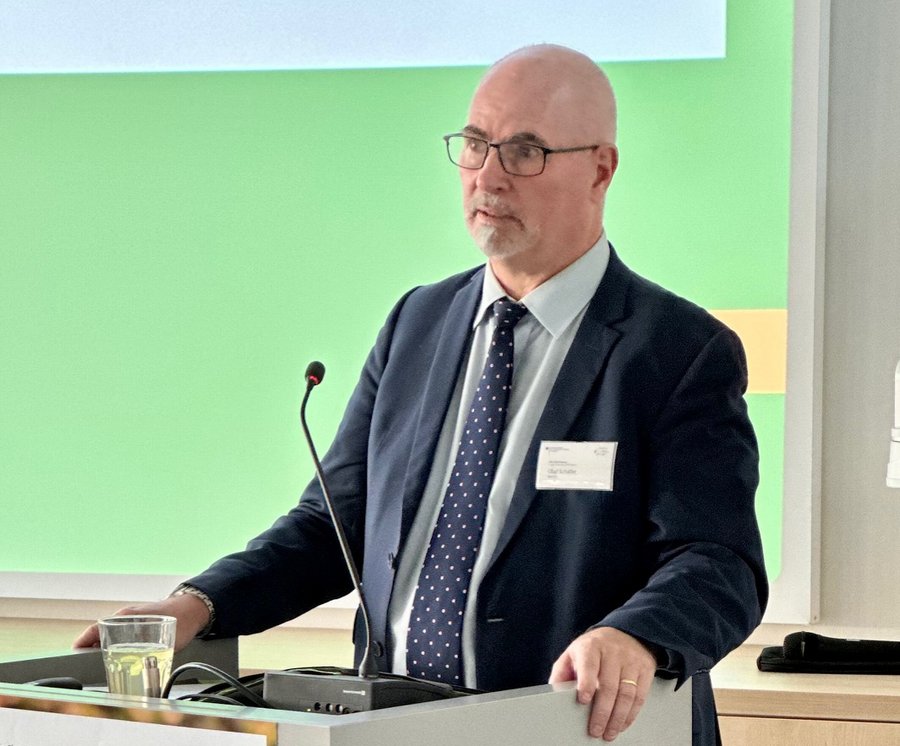 Ein Mann im Anzug steht hinter einem Rednerpult.