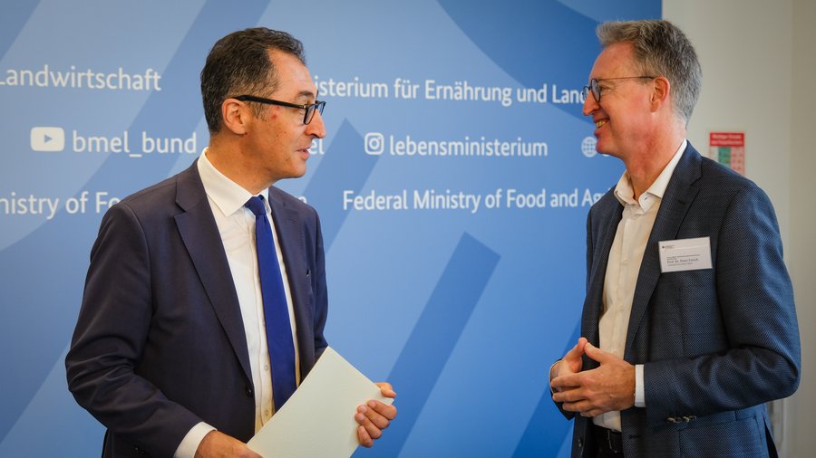 Der Bundeslandwirtschaftsminister und der Vorsitzende des Beirats befinden sich im Gespräch. Sie stehen vor einem blauen Hintergrund und tragen beide einen dunklen Anzug.