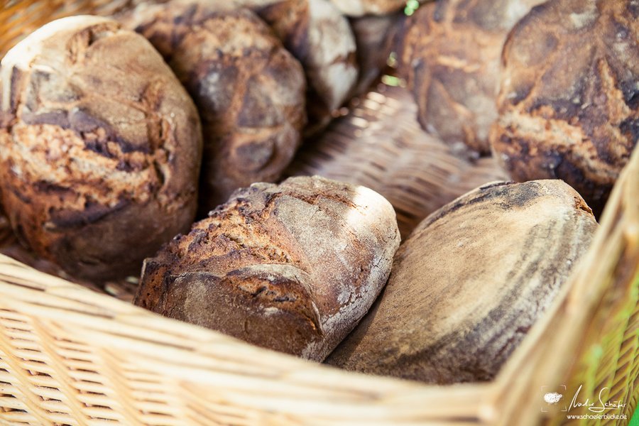 Knusprige dunkelbraune Brötchen liegen aneinandergelehnt in einem Brotkorb.