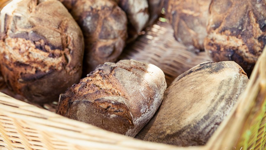 Knusprige dunkelbraune Brötchen liegen aneinandergelehnt in einem Brotkorb.